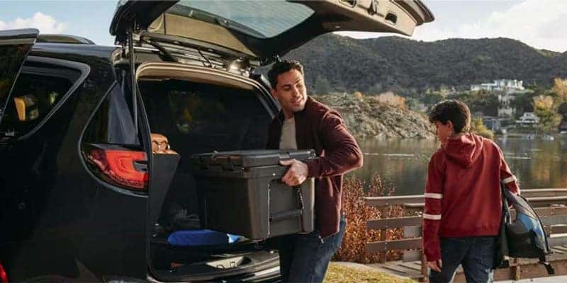 man loading cargo into the back of a 2024 chrysler pacifica