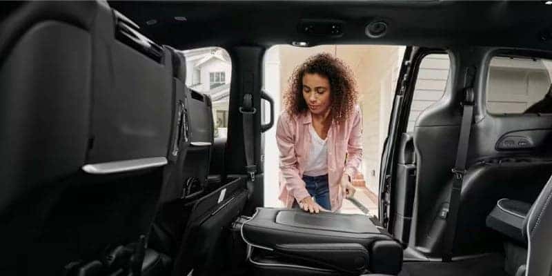 woman folding down seats in a 2024 chrysler pacifica